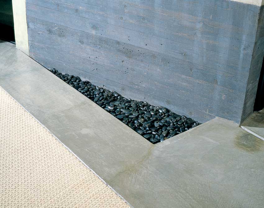 Tumbled river rocks at the base of the Living Wall reflect natural light. Sandra’s home, an aesthetic integration of outside and inside, transforms natural materials into elegant art.
